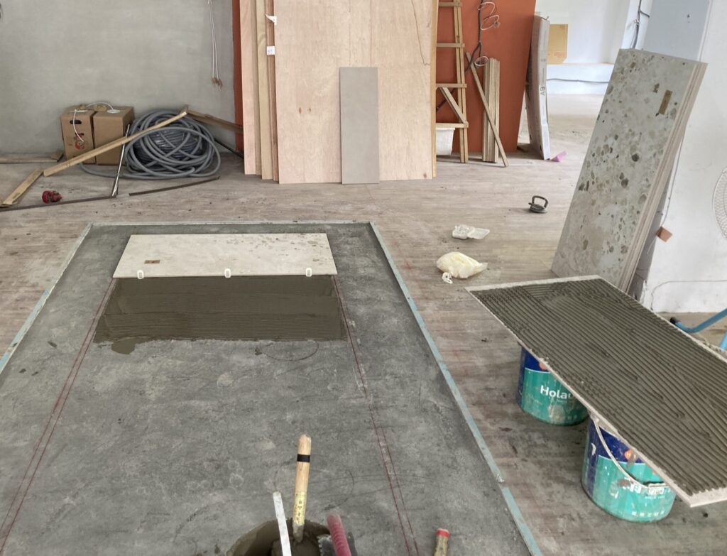 鯊魚劍法貼磚施工，於底層砂漿上大面積刮出鋸齒紋路，提高施工效率並支撐商業空間快速鋪設需求。